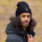 Embroidered Cuffed Beanie worn by a man in a park