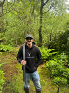 Embroidered Glen Etive Hoodie with British Flag on sleeve in black worn by a model in the countryside front view