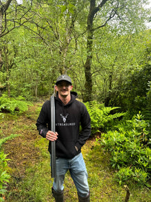 Embroidered Glen Etive Hoodie with British Flag on sleeve in black worn by a model in the countryside front view
