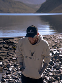 Model on beach wearing Embroidered Glen Etive Hoodie with British Flag on sleeve in sand colour