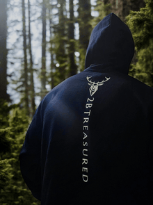 Embroidered Glen Etive Hoodie with British Flag in Navy back view with model in forest