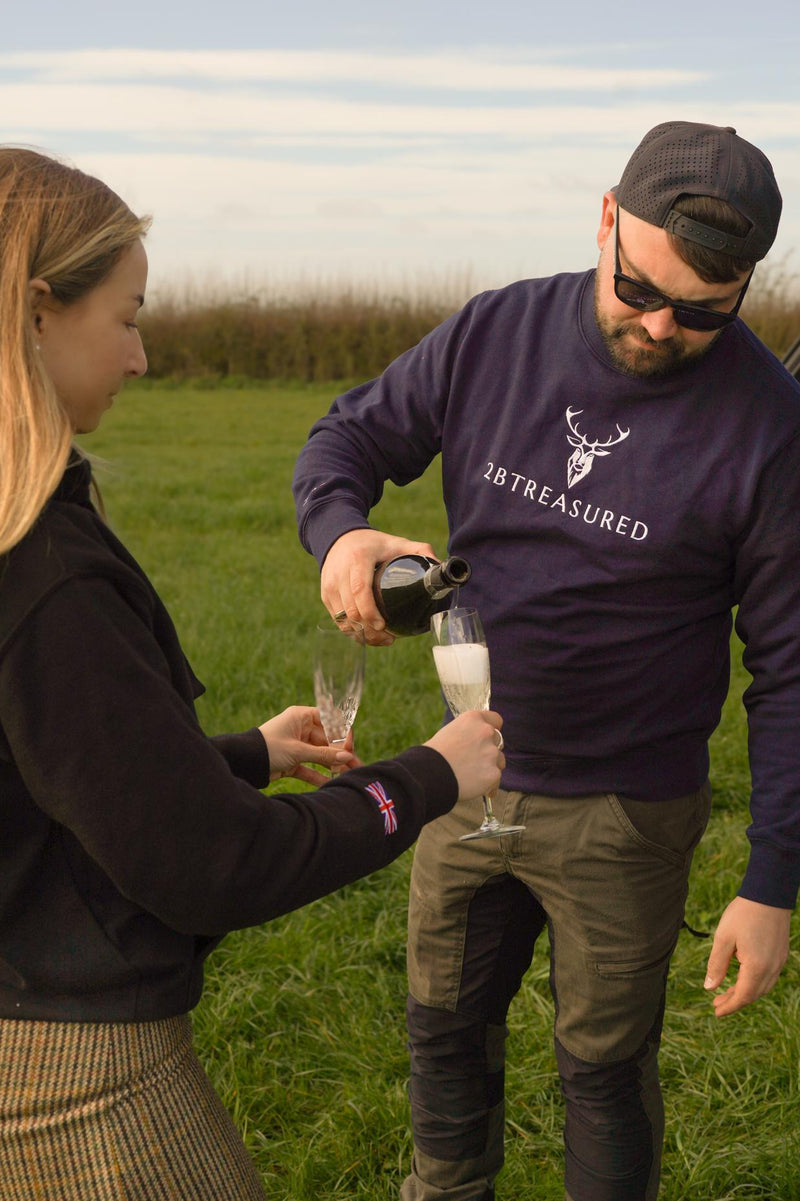 Embroidered Harris Sweatshirt worn by male model pouring champagne in glass