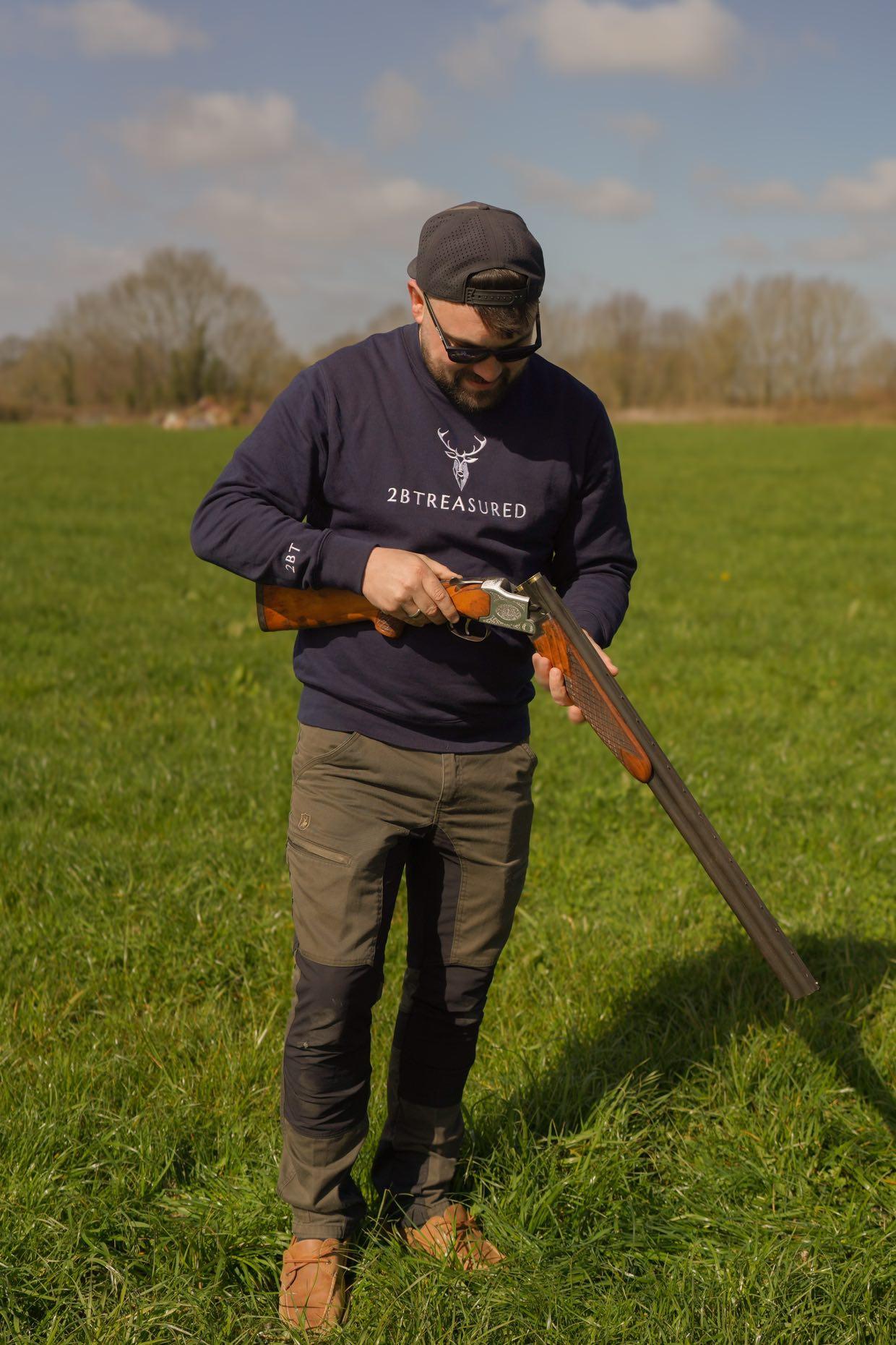 Embroidered Harris Sweatshirt in navy colour modelled by man with shotgun in a field