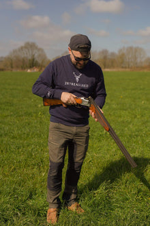 Embroidered Harris Sweatshirt in navy colour modelled by man with shotgun in a field