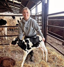 Embroidered Lomond Hoodie modelled by female farmer holding calf