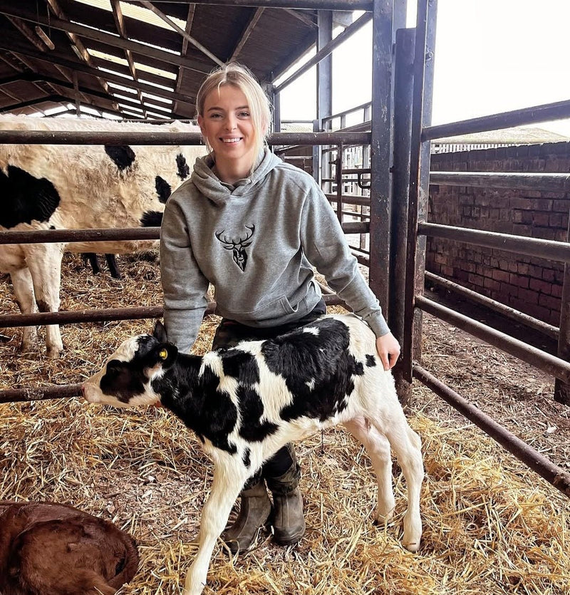Embroidered Lomond Hoodie modelled by female farmer holding calf
