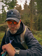 Male modelling the Embroidered Lomond Hoodie w British Flag close up view with trees in the background