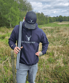 Man wearing the Embroidered Lomond Hoodie with British Flag in Navy in countryside setting