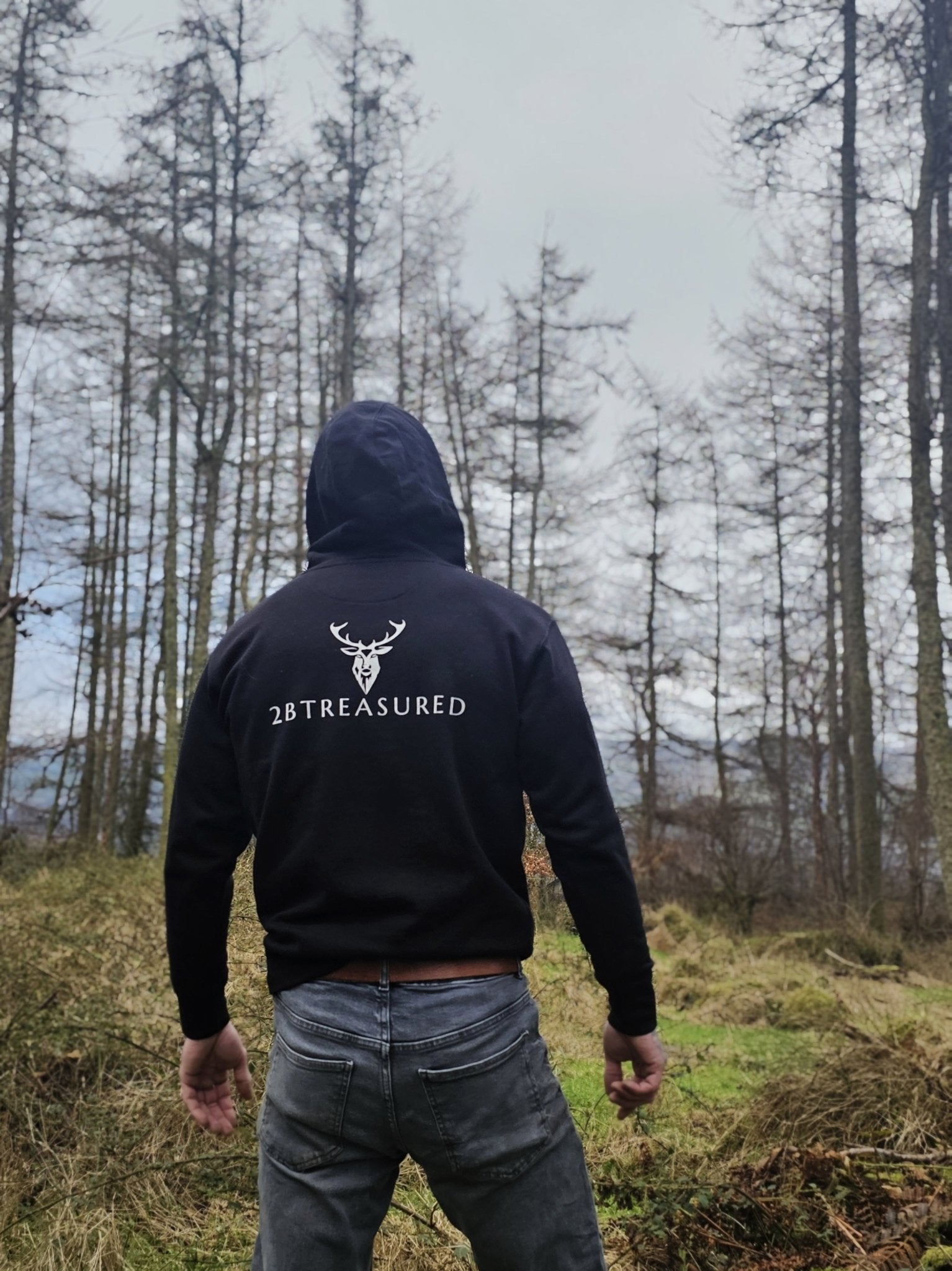 Male model wearing the Embroidered Stag Lomond Hoodie in Black back view from 2BTreasured