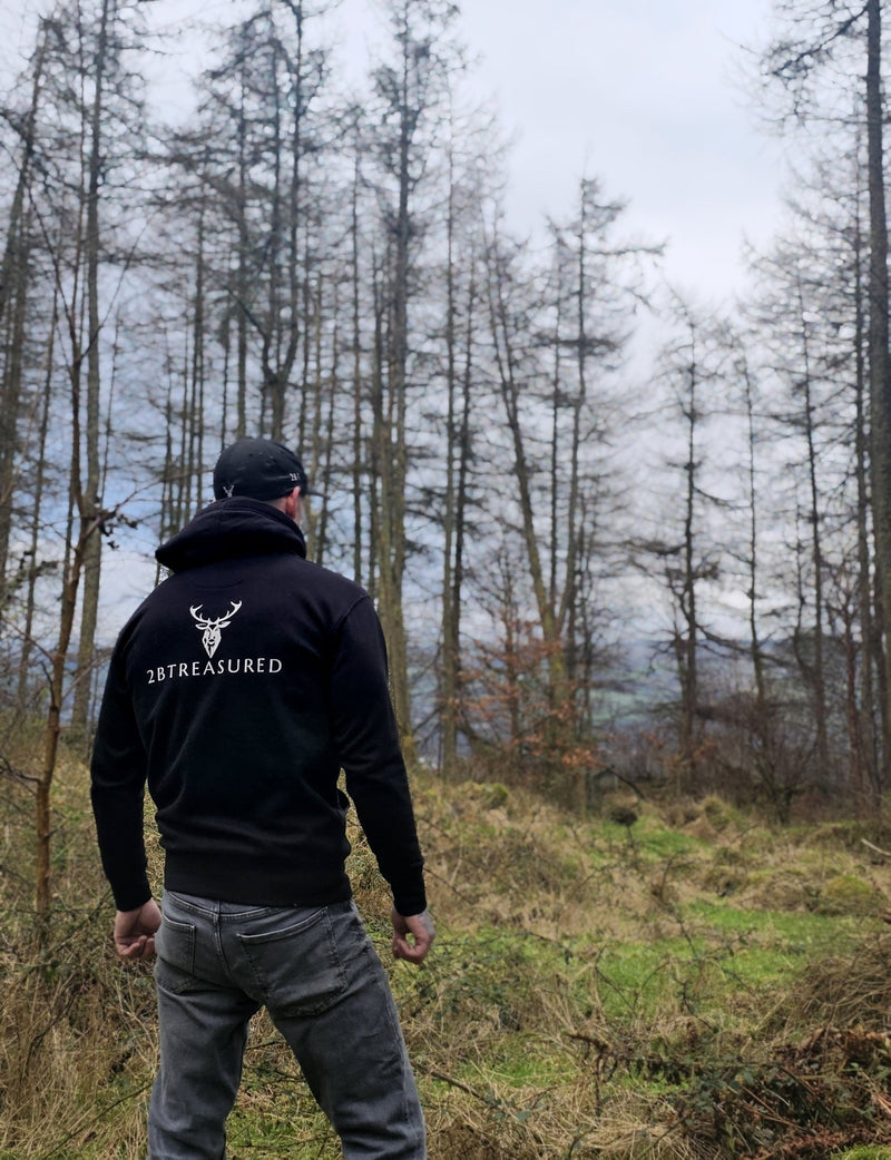 Embroidered Stag Lomond Hoodie in Black worn by male model in a forest back view