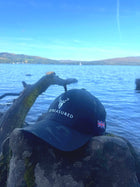 Embroidered Structured Camo Cap Multicam with British Flag on a rock next to lake