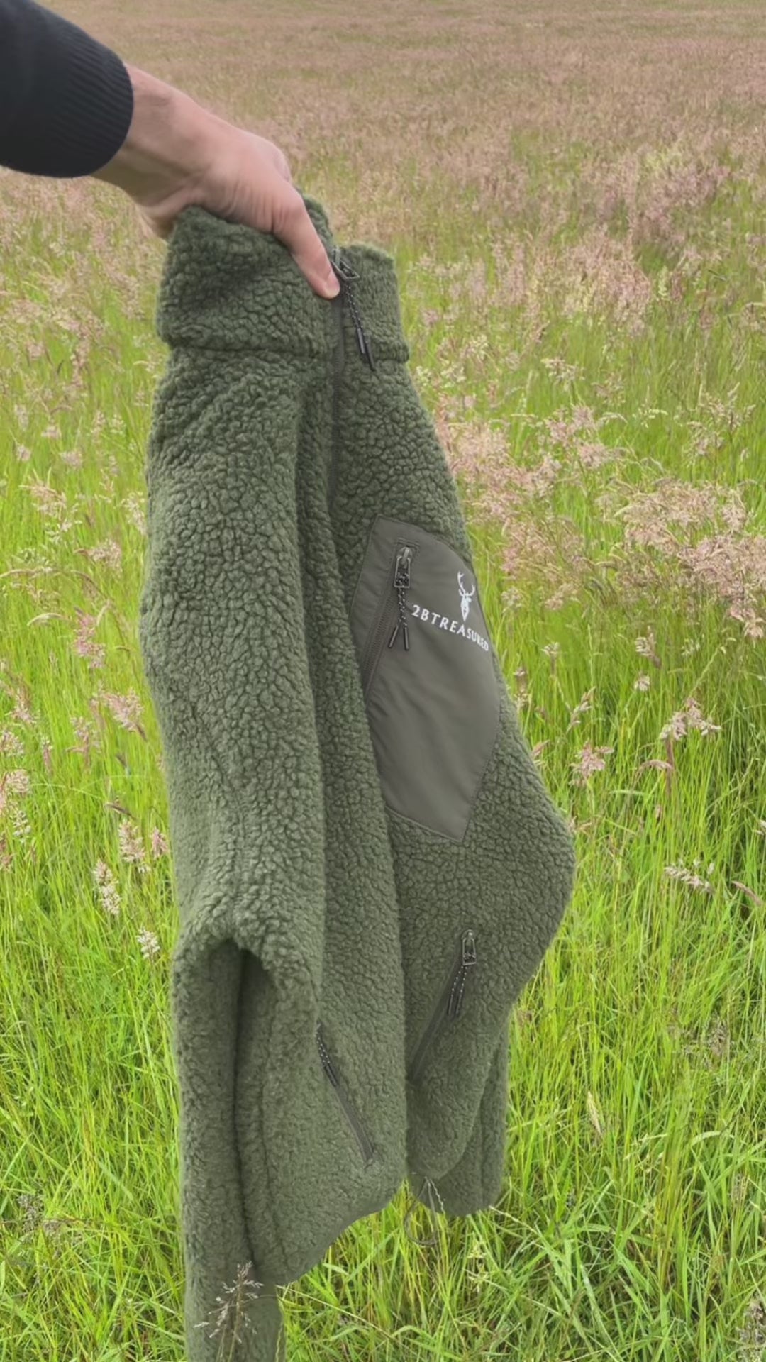 Man modelling army green sherpa fleece, walking in countryside