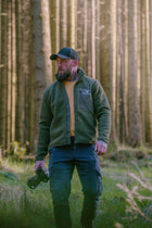 Man posing in the Snowdon Sherpa Fleece Army Green front view in a forest 