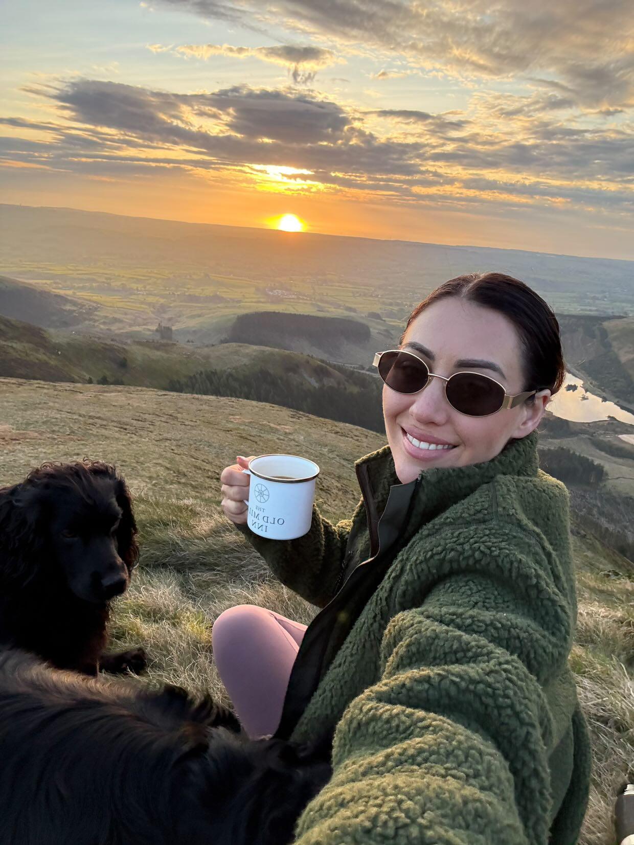 Female model in the Snowdon Sherpa Fleece Army Green colour on top of a hill with sunset