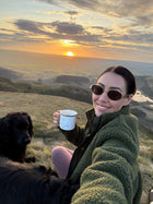 Female model in the Snowdon Sherpa Fleece Army Green colour on top of a hill with sunset