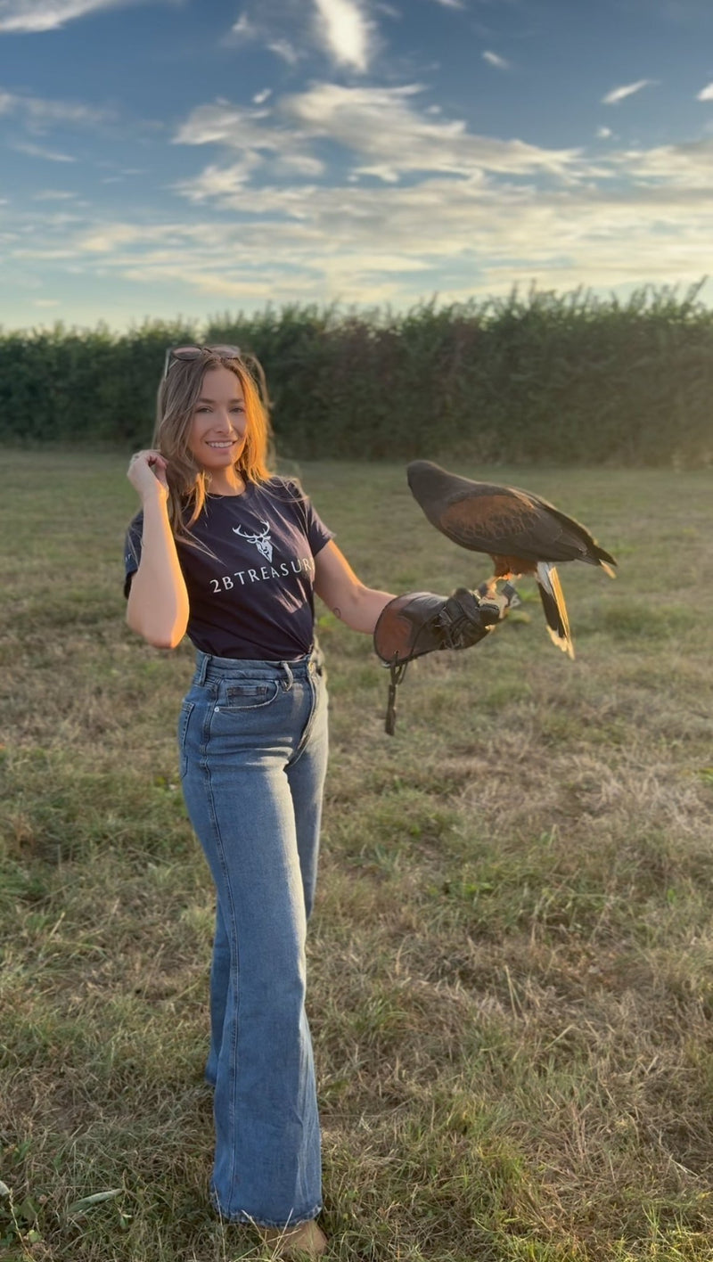 Model string in field holding hawk wearing thistle Tshirt